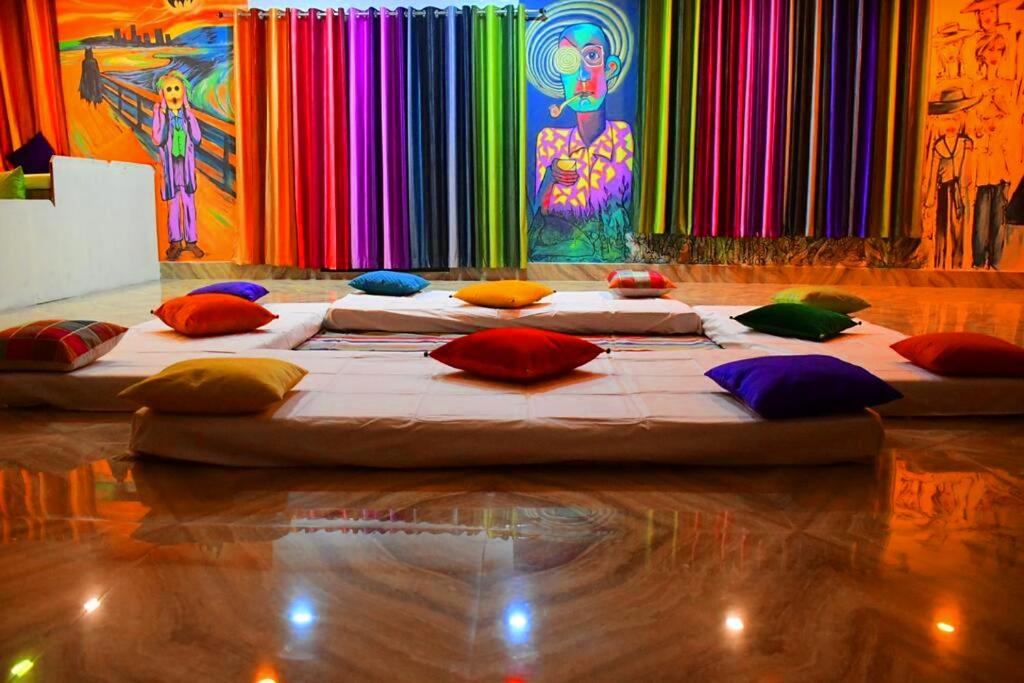 瓦拉纳西Gypsy Diaries Varanasi的一张大床,配有色彩缤纷的枕头