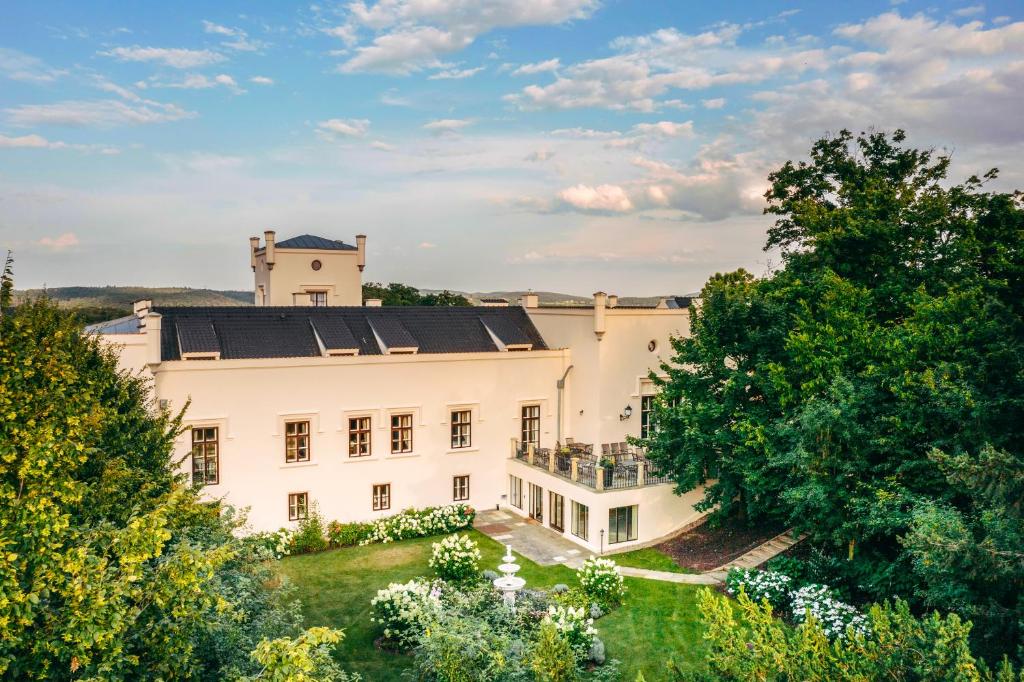 TrnowaHotel & Restaurant Chateau Trnová的享有树木繁茂的白色大房子的空中景致
