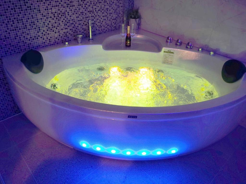 惠灵顿新地苑汽车旅馆的浴室内设有带灯的大浴缸