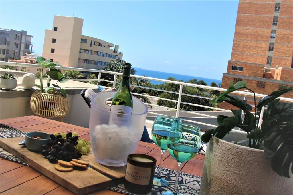 德班Luxury Apartment in Umhlanga Rocks的一张桌子上摆放着一瓶葡萄酒和酒杯