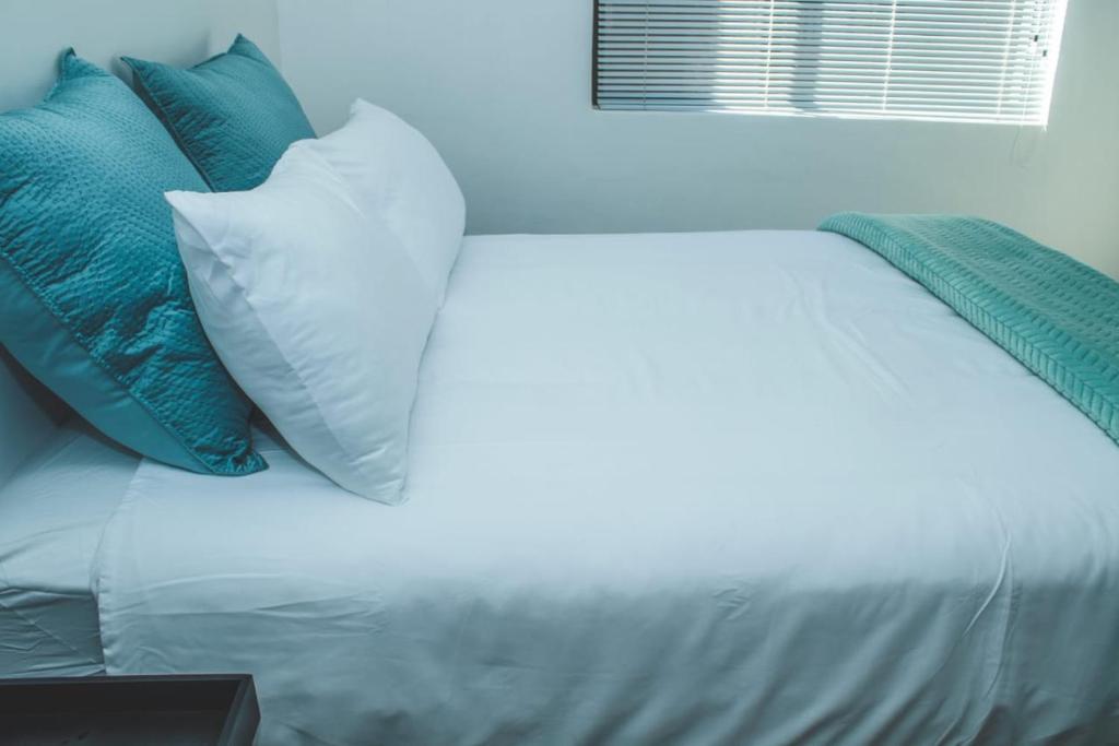 波罗瓜尼Platinum Apartment的一张带蓝色和白色枕头的床