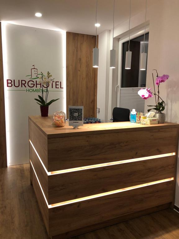 霍姆贝格Burghotel Homberg的酒店前台设有木制台面