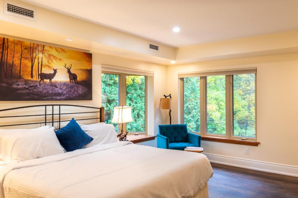 亨茨维尔Fairy Bay Lakehouse的一间卧室配有一张床、一张蓝色椅子和窗户。