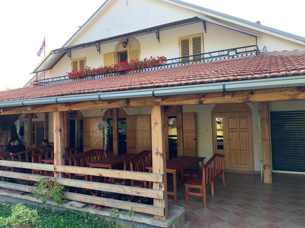 IrigDomaćinstvo Bakić的大楼内的餐厅,配有木桌和椅子