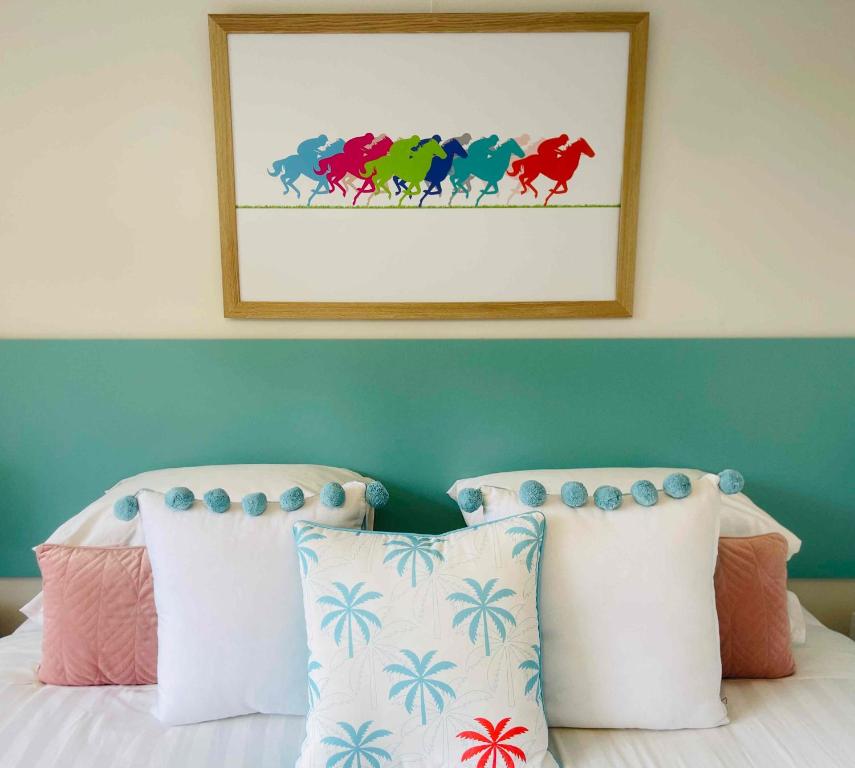 沃纳姆堡Botanic Racecourse的卧室配有一张床铺,墙上挂着马匹的照片