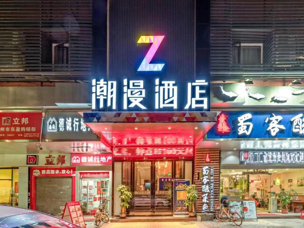 广州潮漫酒店(广州琶洲会展中心赤岗地铁站店)的建筑物一侧有 ⁇ 虹灯标志的商店