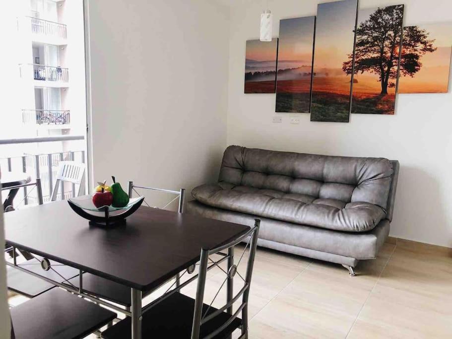 比亚维森西奥Moderno APTO con aire acondicionado y Netflix en Villavicencio的客厅配有真皮沙发和桌子
