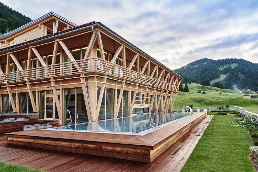 巴尔德赫旺HUBERTUS Mountain Refugio Allgäu的一座木屋,前面设有一个游泳池