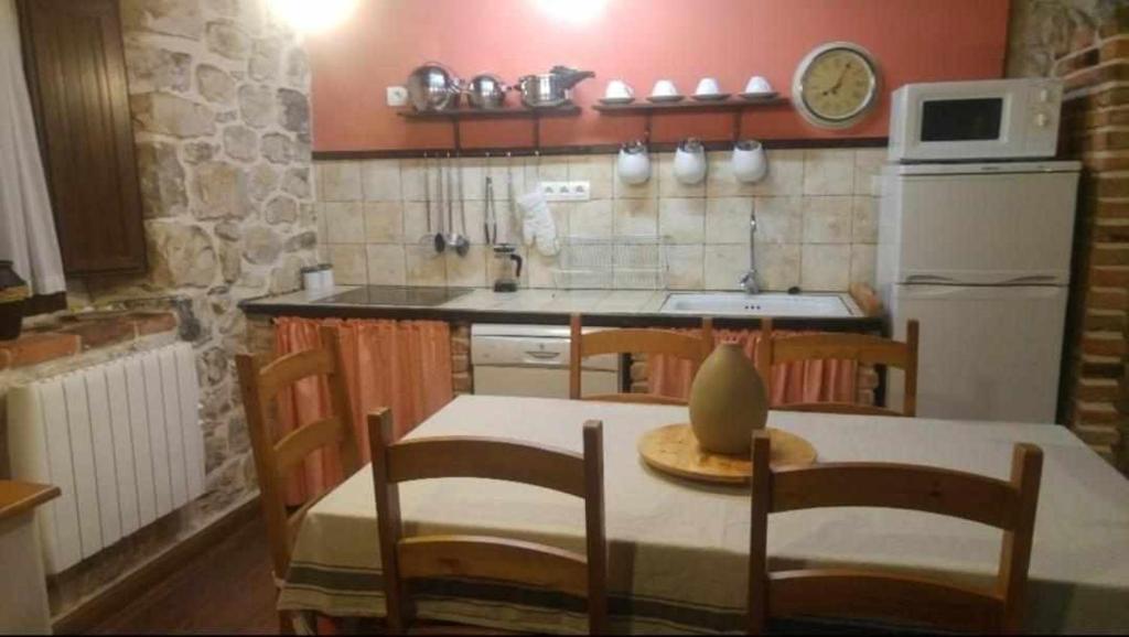 Poo de CabralesLa Gesta Picos de Europa的厨房配有桌椅和冰箱。