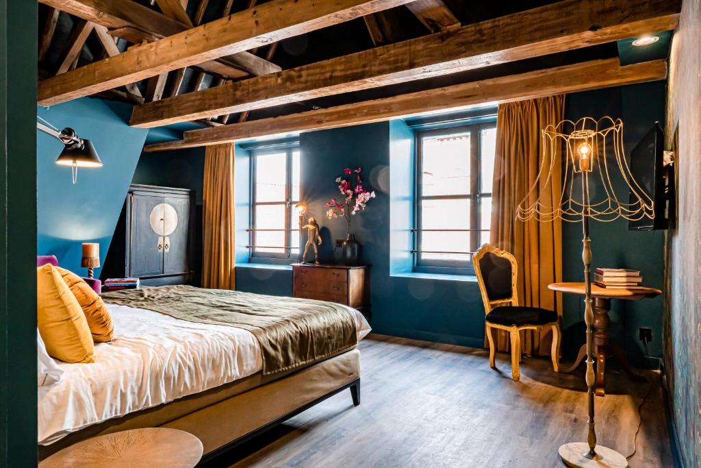 哈莱姆MAF Haarlem Boutique Hotel的一间拥有蓝色墙壁的卧室,配有一张床和一张桌子