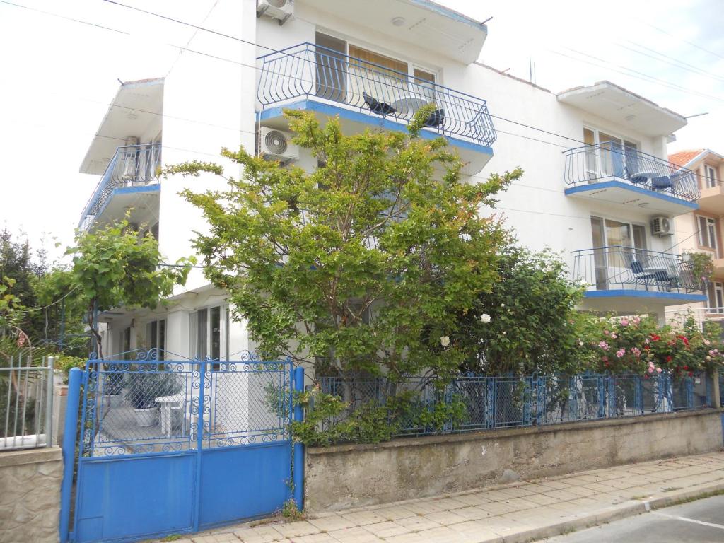 阿赫托波尔"Agatopolis" - подсигурено безплатно паркиране的一座建筑,前面有蓝色的大门和一棵树