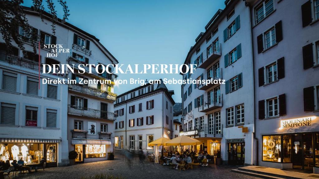 布里格Hotel Stockalperhof的城市街道,有建筑和坐在桌子上的人