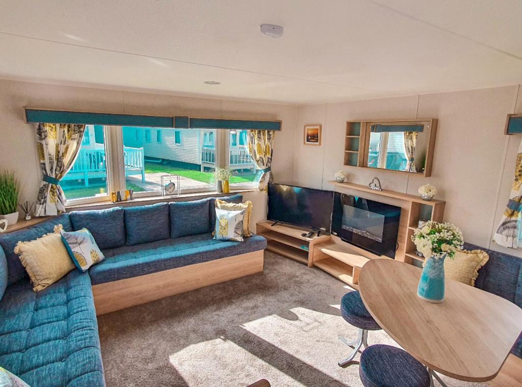 HumberstonSpacious Caravan - Thorpe Park Cleethorpes的客厅配有蓝色的沙发和电视