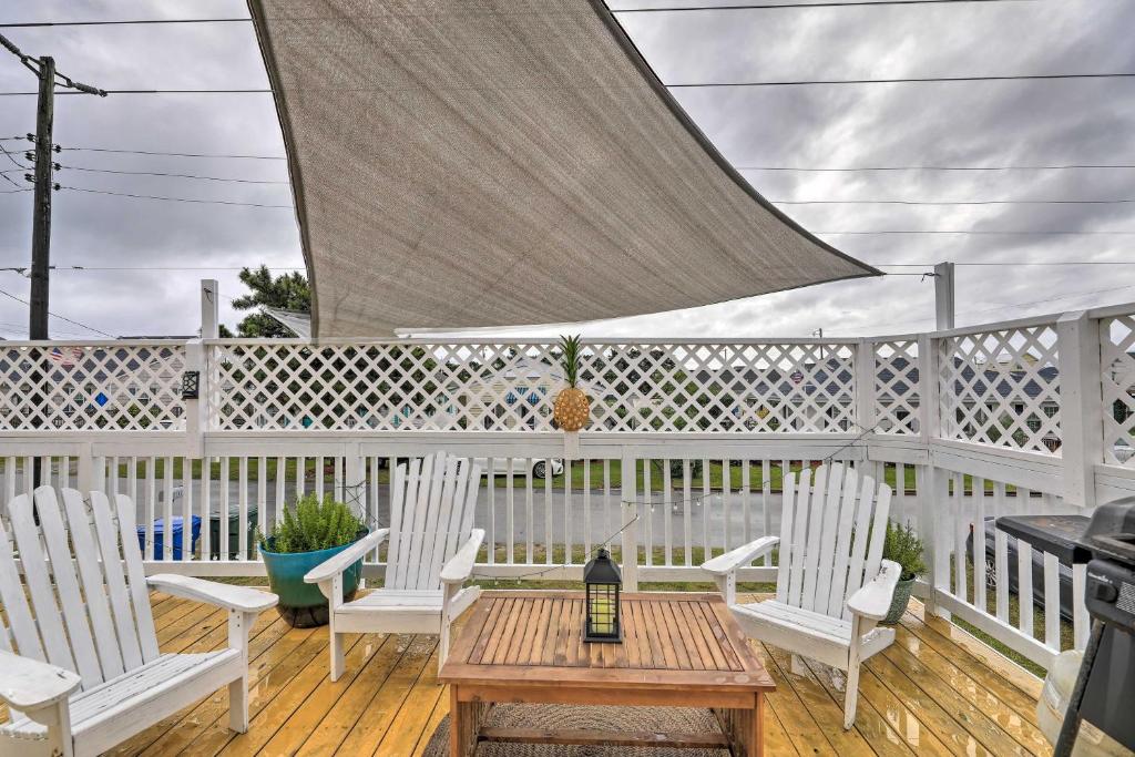 大西洋滩Pet-Friendly Townhome, 2 Blocks to Atlantic Beach!的庭院配有白色的椅子和一张桌子,并提供一瓶葡萄酒