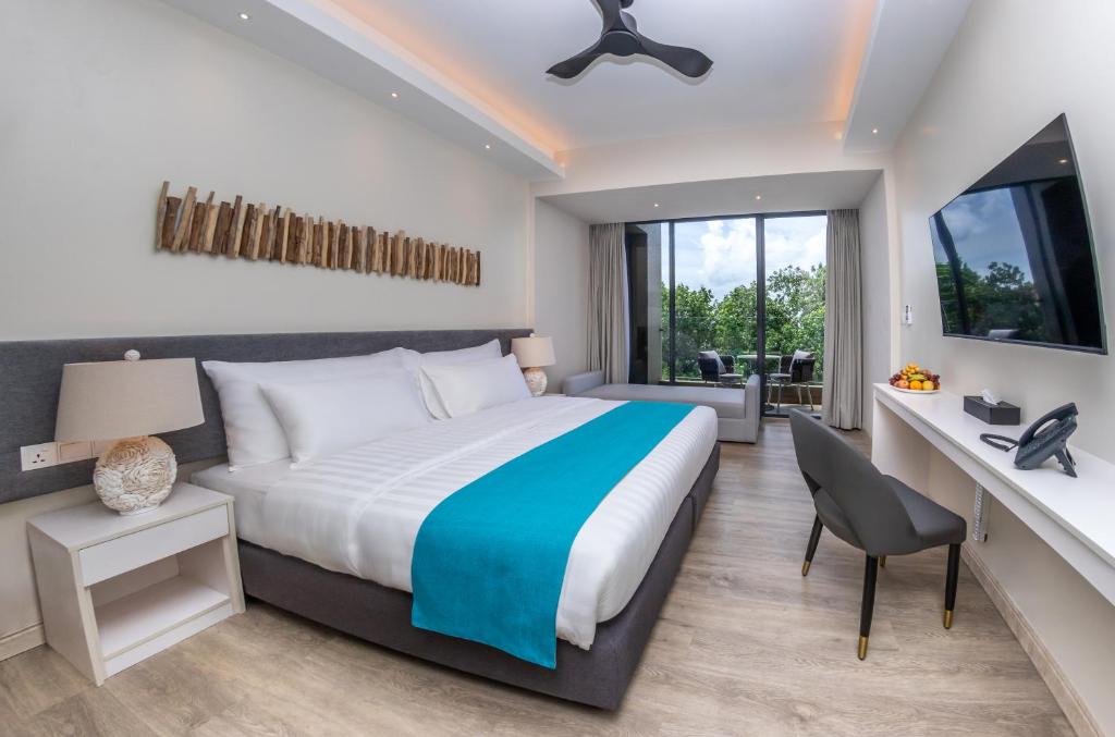 迪弗西Sky Beach Maldives - Dhiffushi的一间卧室配有一张床和一张桌子及椅子