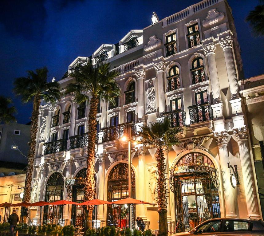 都拉斯Hotel Epidamn Boutique & Spa的一座棕榈树环绕的大建筑