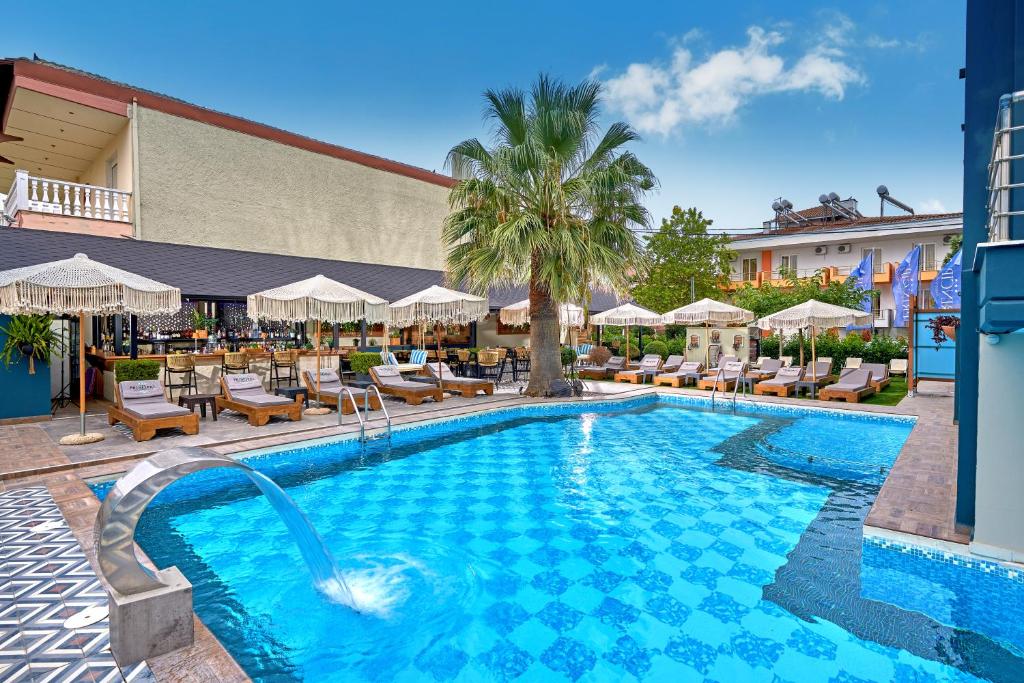 帕拉利亚卡泰里尼斯Principal New Leisure Hotel的一个带椅子和遮阳伞的游泳池
