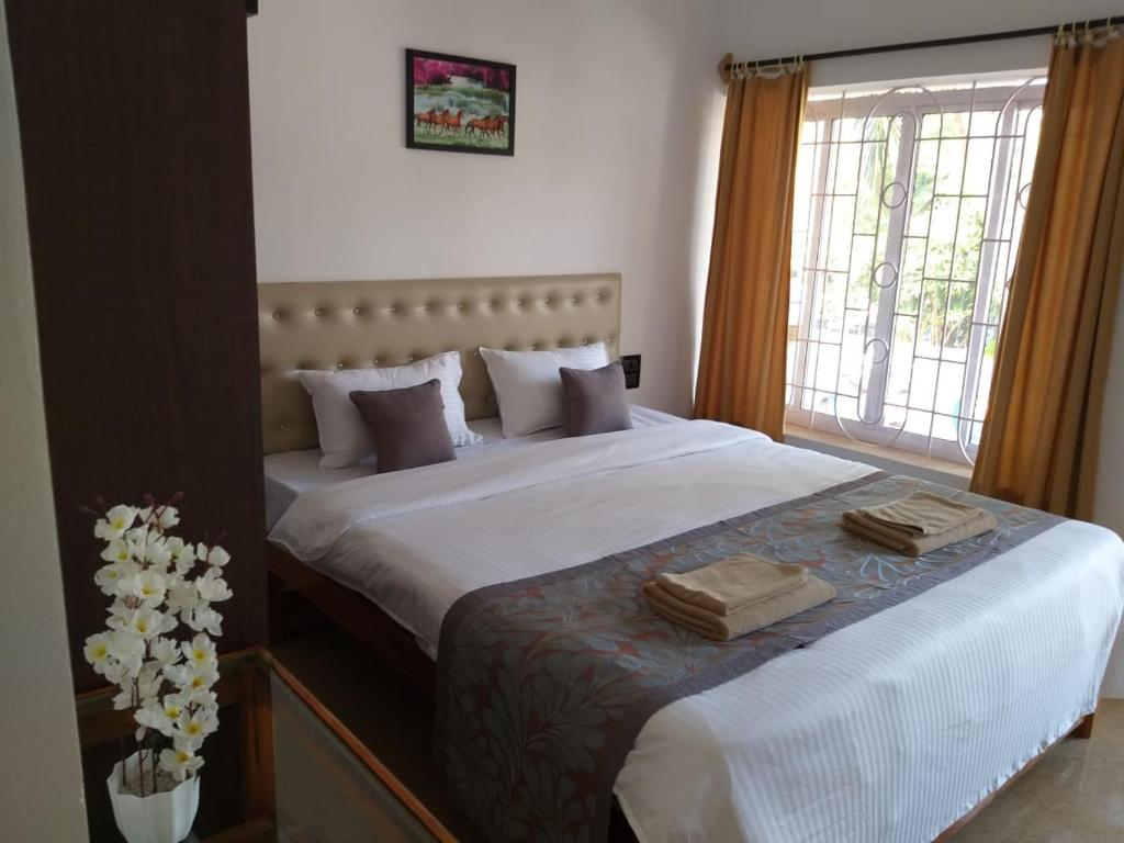 阿贡达Oasis Beach Resort的一间卧室配有一张大床和两条毛巾