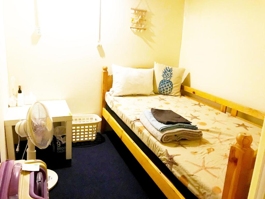 石垣岛石垣岛美宿酒店的一间带一张床和风扇的小卧室