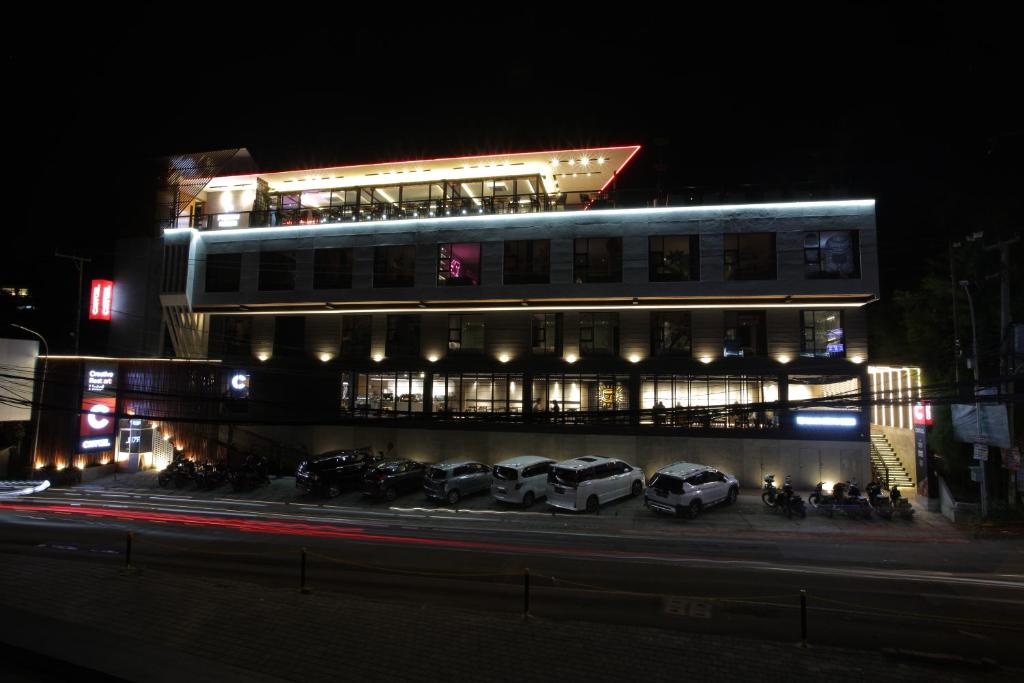 万隆Creative Restart Hotel - CARTEL Bandung的一座建筑,晚上停在前面