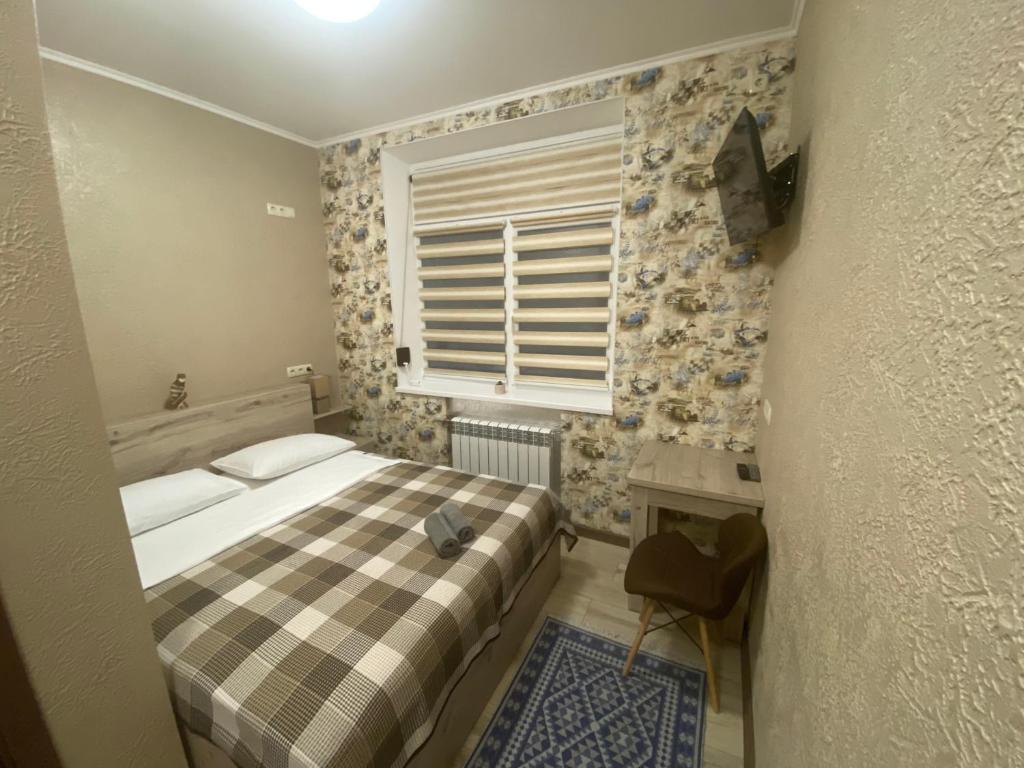 波尔塔瓦Вігвам的一间小卧室,配有床和窗户
