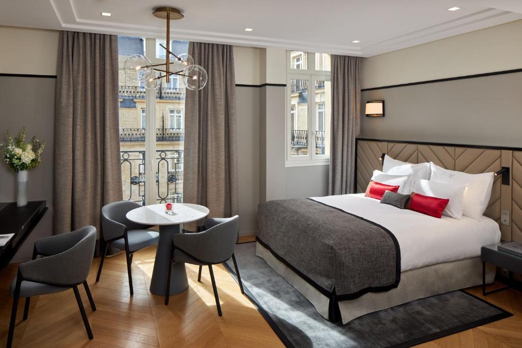 巴黎巴黎香榭丽舍辉盛阁国际公寓的酒店客房带一张床、一张桌子和椅子