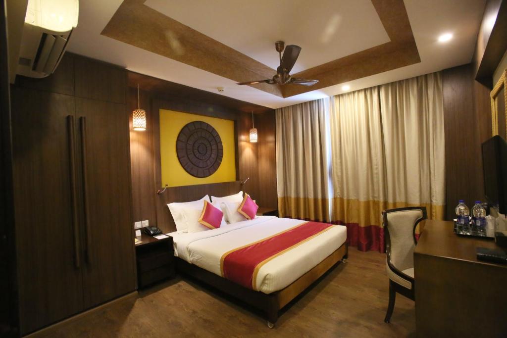 特里凡得琅Vivin Luxury Suites的酒店客房配有一张床、一张桌子和一把椅子。