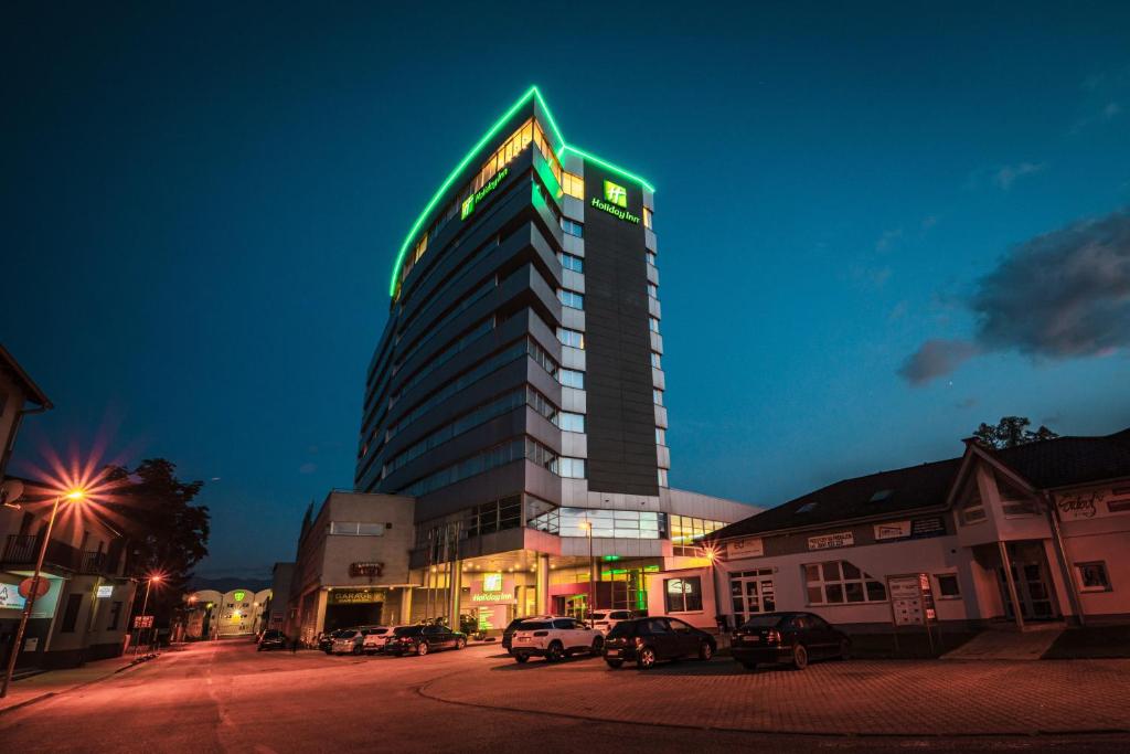 日利纳吉利纳假日酒店的上面有绿色 ⁇ 虹灯标志的高楼