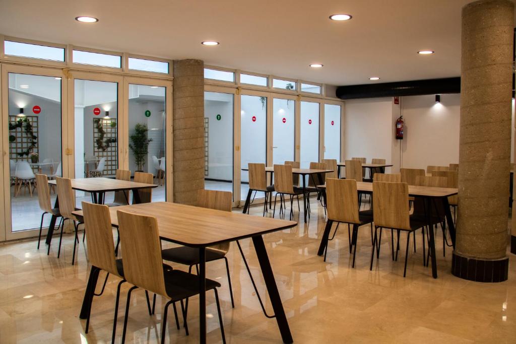 拉科鲁尼亚Hotel Alda Orzán的餐厅设有桌椅和窗户。