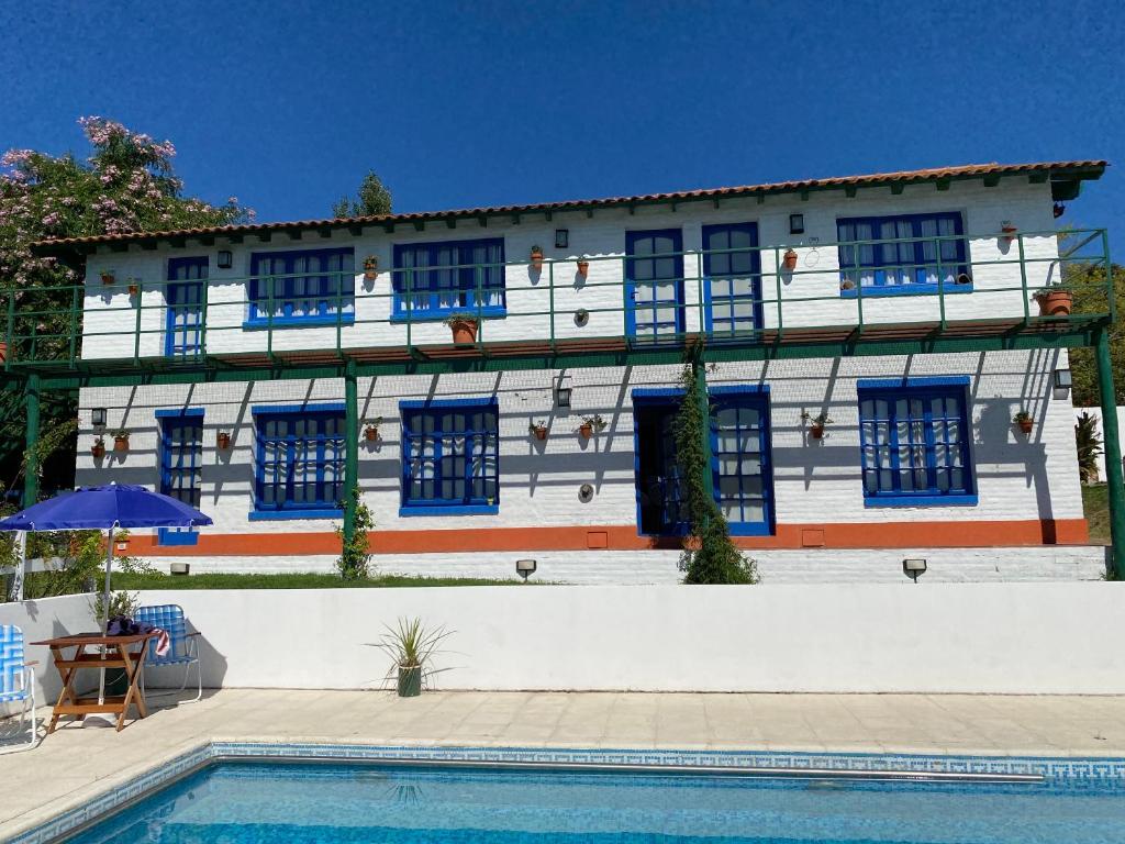 坦迪尔Clara en el Cerro的一座带蓝色窗户和游泳池的建筑