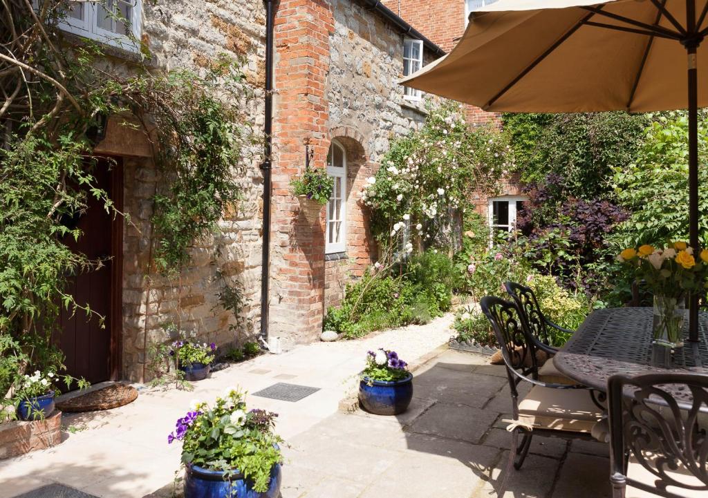 斯托尔河畔希普斯顿老科林客舍的庭院配有遮阳伞和桌椅。