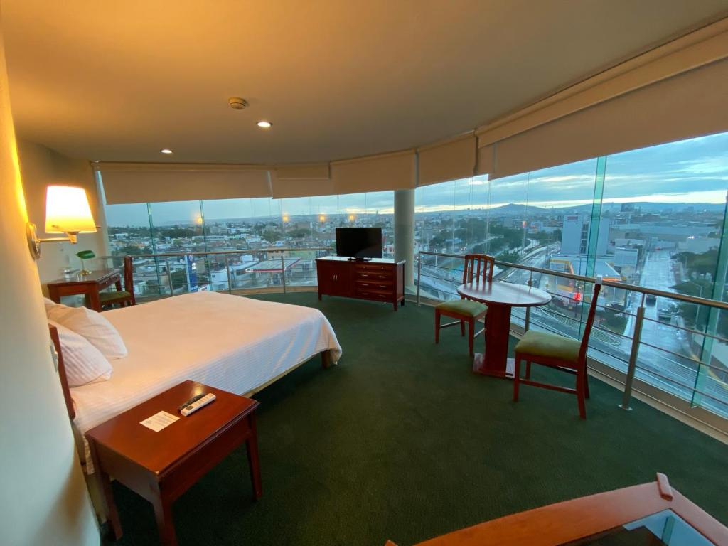 莱昂Hotel Enterprise Inn Poliforum的酒店客房设有一张床和一个美景阳台