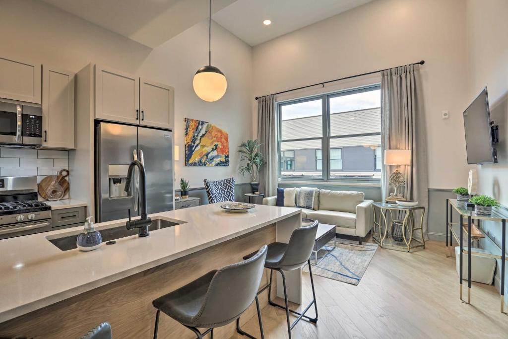 伯明翰Modern Downtown Birmingham Condo with Rooftop Access的厨房以及带柜台和椅子的客厅。