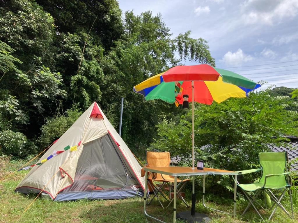 筑紫野市Yamabitoan - Vacation STAY 96154的帐篷和一张带五颜六色雨伞的桌子