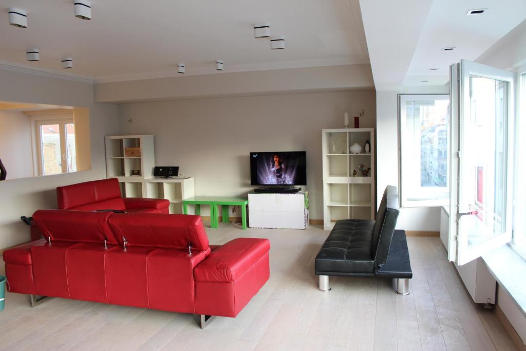 奥斯坦德Golden Tulip的客厅配有红色的沙发和椅子