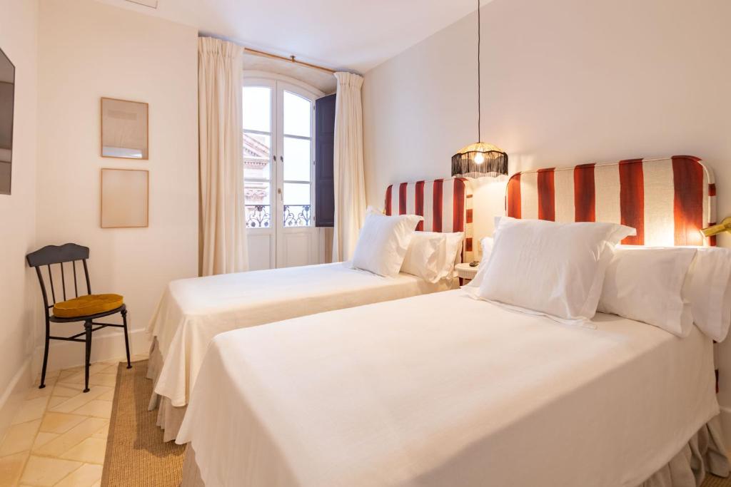 塞维利亚Casa de la Moneda Residences Sevilla的有两张床和一扇窗户的酒店房间