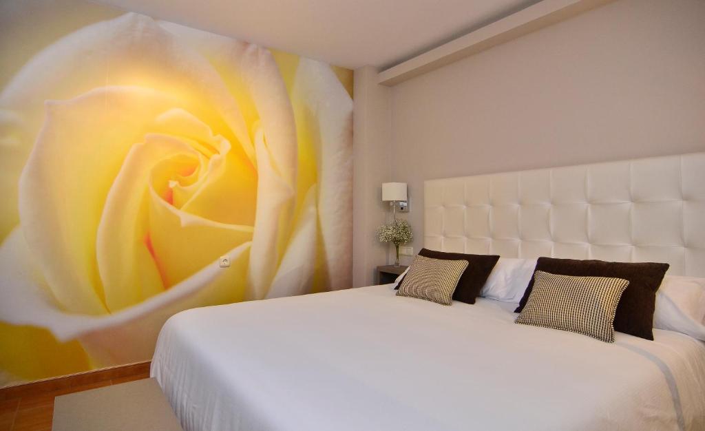 坎加斯德穆拉索朱卡玛酒店的卧室配有白色床,墙上挂有花卉画