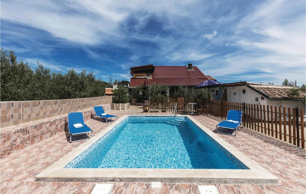 瓦图拉Stunning Home In Valtura With 4 Bedrooms, Wifi And Outdoor Swimming Pool的一个带蓝色椅子的游泳池