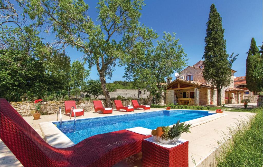 ManjadvorciAwesome Home In Manjadvorci With Wifi的一个带红色椅子的游泳池