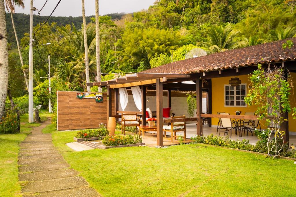 Saco do CeuPousada Gata Russa的房屋设有带桌椅的庭院