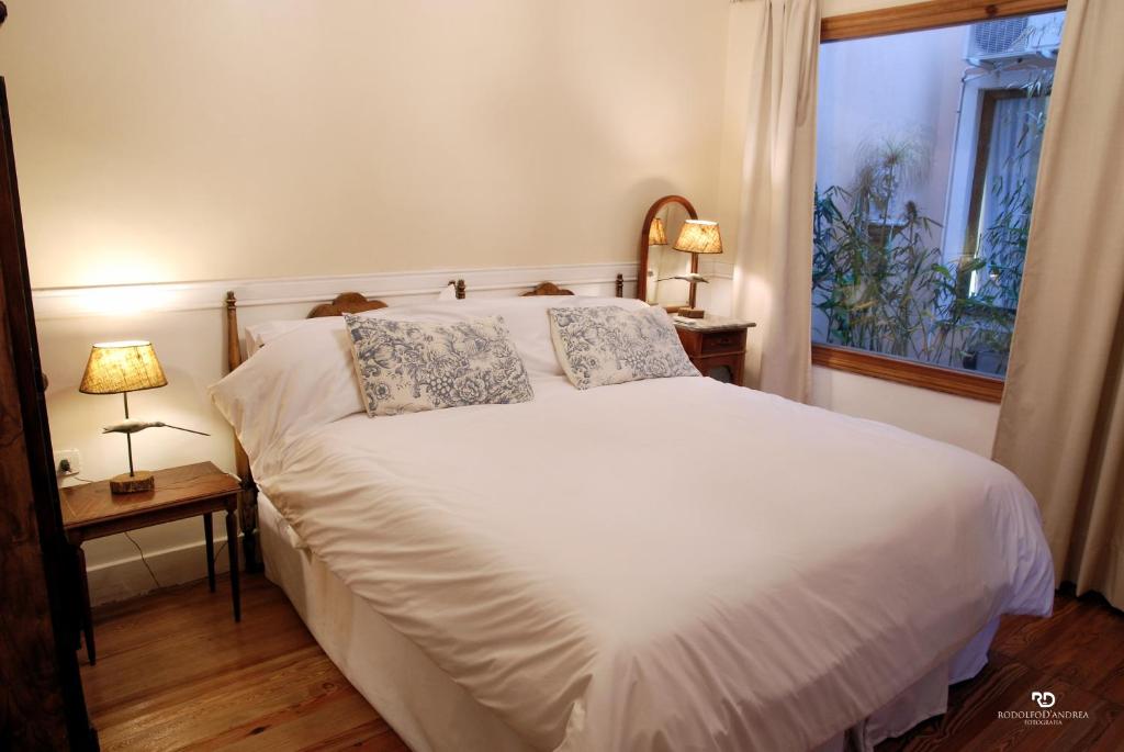 胡宁Casa Viva Hotel Boutique的卧室配有白色床、两盏灯和一扇窗户。