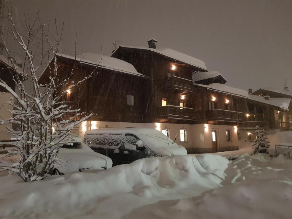 利维尼奥卡曼尼尔度假屋的雪覆盖的房屋,晚上有灯