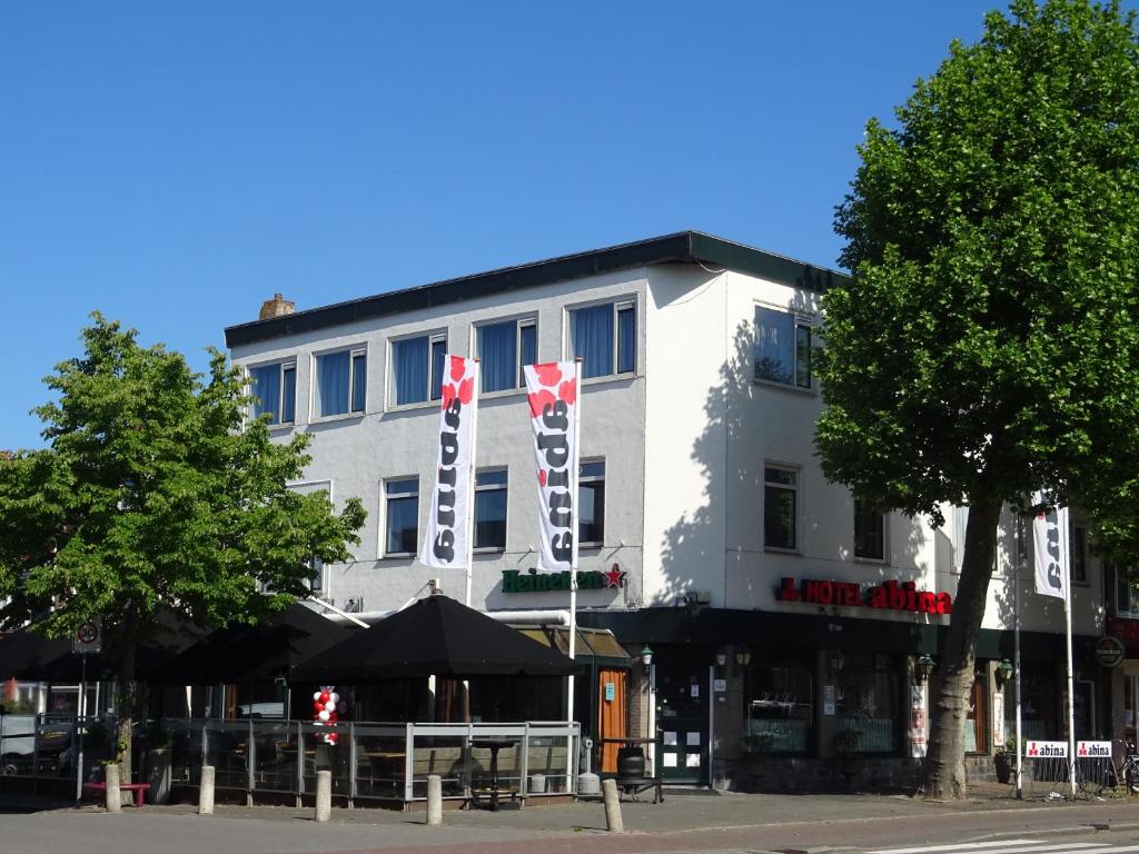 阿姆斯特尔芬阿比纳咖啡餐厅酒店的前面有旗帜的白色建筑