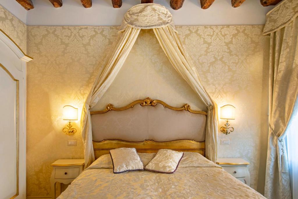 威尼斯帕塔蒂娜住宿加早餐旅馆的一间卧室配有一张天蓬床和两个枕头