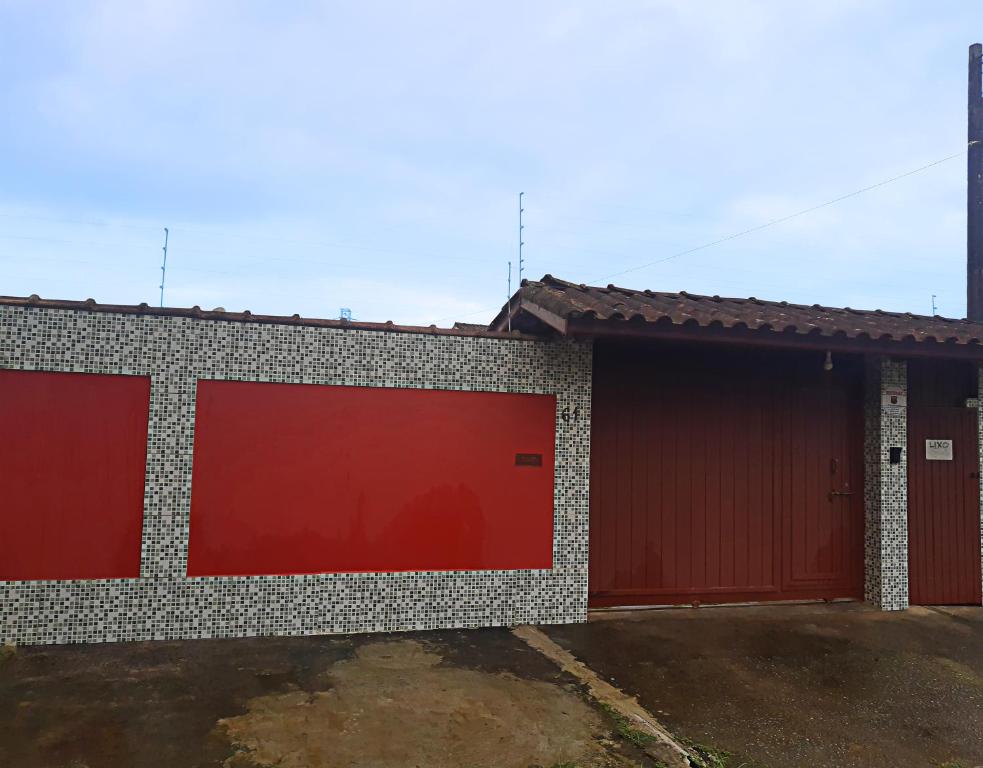 乌巴图巴Ubatuba Beach House的一座建筑,设有两个带红色门的车库