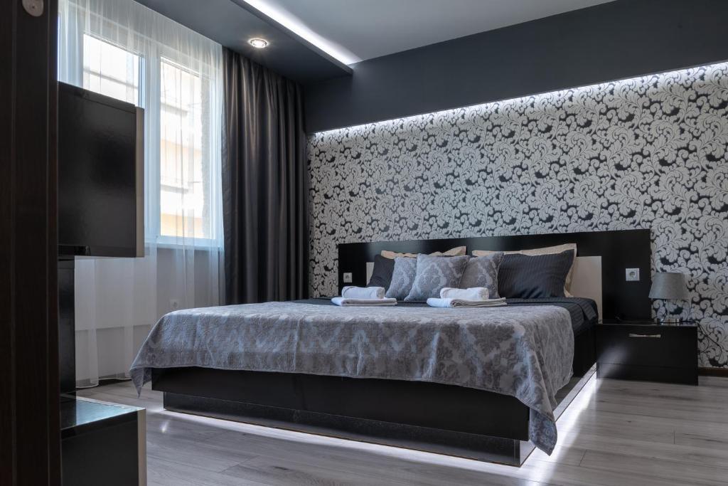 大特尔诺沃Apartment Central-LUX 1的一间卧室设有一张床,墙上配有电视。