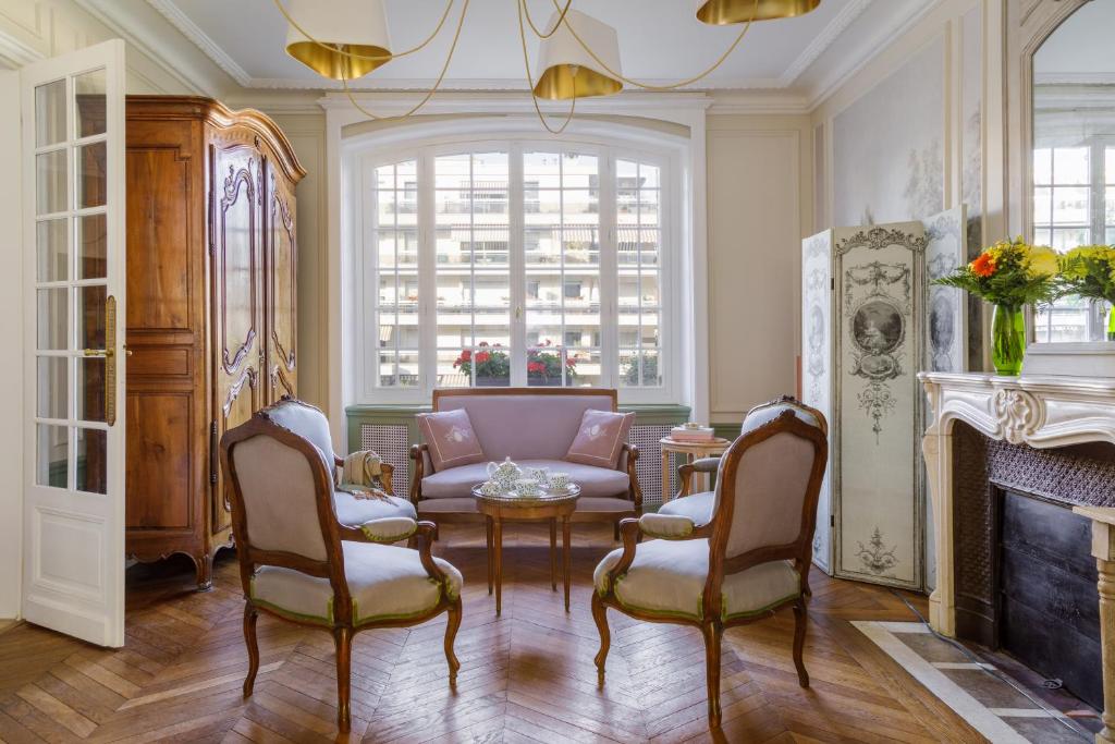 阿涅勒L'Hôtel Particulier - Paris Asnières的客厅配有沙发、椅子和壁炉