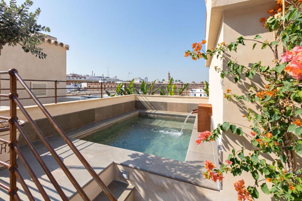 塞维利亚Casa de la Moneda Residences Sevilla的建筑物侧面的游泳池