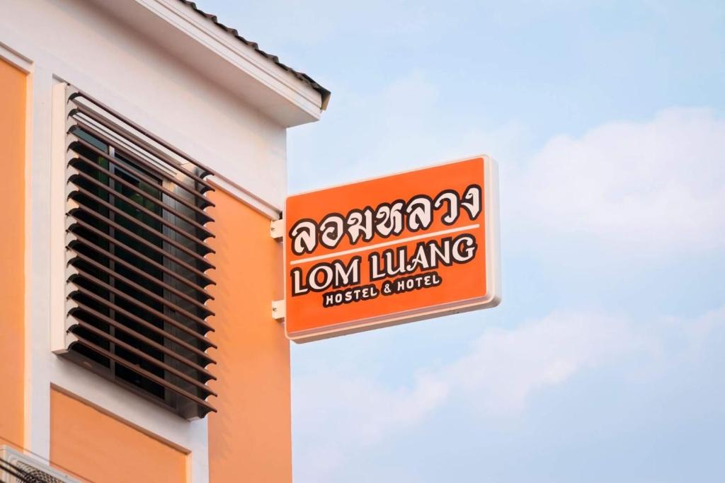 南府Lomluang hostel&hotel的狮子在建筑物边的标志