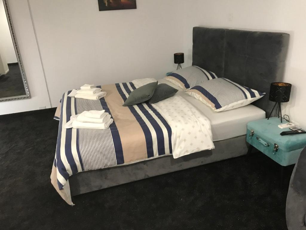 大戈里察WooW Apartments的一间卧室配有带条纹床单和枕头的床